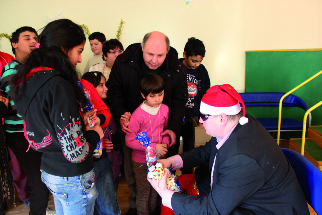 Bild:Janoschek übergibt Weihnachtsgeschenke in einem Waisenheim